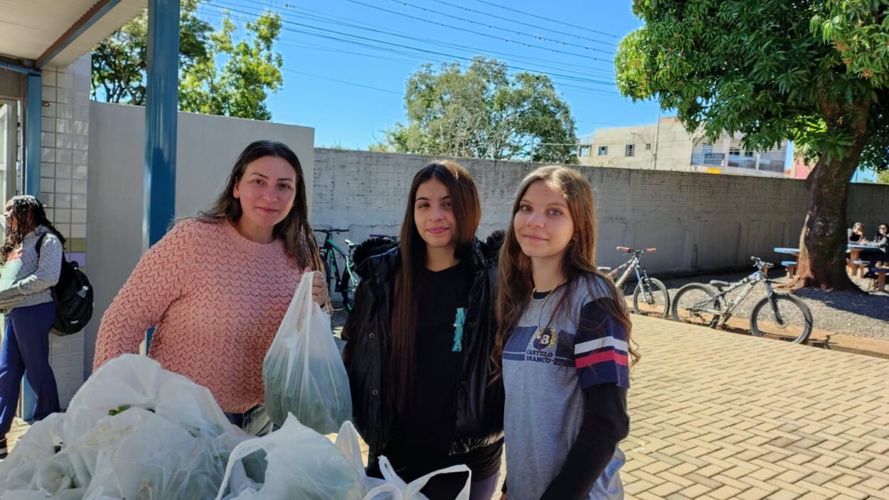A galeria mostra fotos dos clubistas entregando as alfaces que eles cultivaram aos pais e alunos da escola. Há ambientes internos e externos e as alfaces estão envolvidas em sacolas plásticas para a praticidade no transporte. Alguns adultos são pais dos alunos e seguram pacotes contendo uniformes escolares.