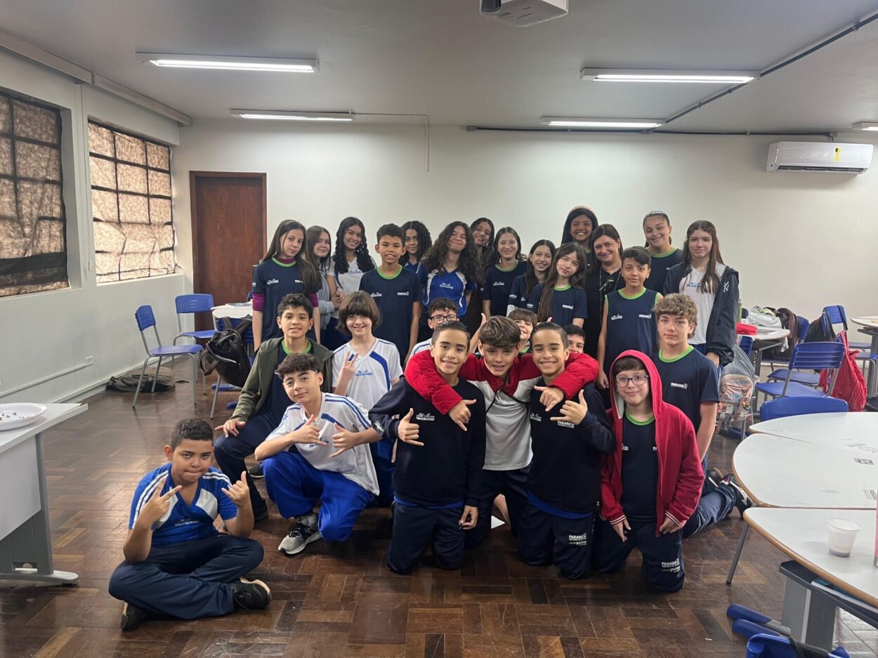 A primeira foto é do Clube de Ciências ‘Cienteens’ do Colégio Instituto de Educação Estadual de Maringá. Na imagem, vemos um grupo de onze pessoas posando dentro de uma sala de aula. A maioria são jovens estudantes, acompanhados por uma mulher adulta, que é a professora, posicionada no centro da foto. Na segunda fotografia há um grupo de seis pessoas do Clube ‘Capivara´s Tech’, estudantes e uma professora, posando sorridentes em frente a um painel que diz "Clube de Ciências - Capivara’s Tech". Eles estão sentados em bancos e mesas. Há pequenos vasos de planta como decoração. A terceira imagem mostra um grupo de estudantes do Clube Paulo Sérgio Bretones em uma sala de aula. São aproximadamente 30 pessoas, sendo alunos e professora. O ambiente é uma sala de aula com mesas redondas, cadeiras azuis e um piso de madeira escura. Há um ar-condicionado fixado na parede ao fundo e luminárias no teto. Algumas mochilas e materiais escolares estão ao redor da sala. A quarta foto tem um grupo de alunos apresentando um projeto do Clube ‘Robótica e Sustentabilidade, Solidariedade em Ação’ em uma sala decorada com folhas verdes penduradas. Na frente da mesa, há cartazes escritos e materiais como garrafas PET e experimentos.