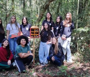 Estudantes do Clube Raízes da Ciência, acompanhados da professora Mariana  Mendes Mirkoski, durante a instalação do hotel de insetos (Foto/Arquivo Pessoal)