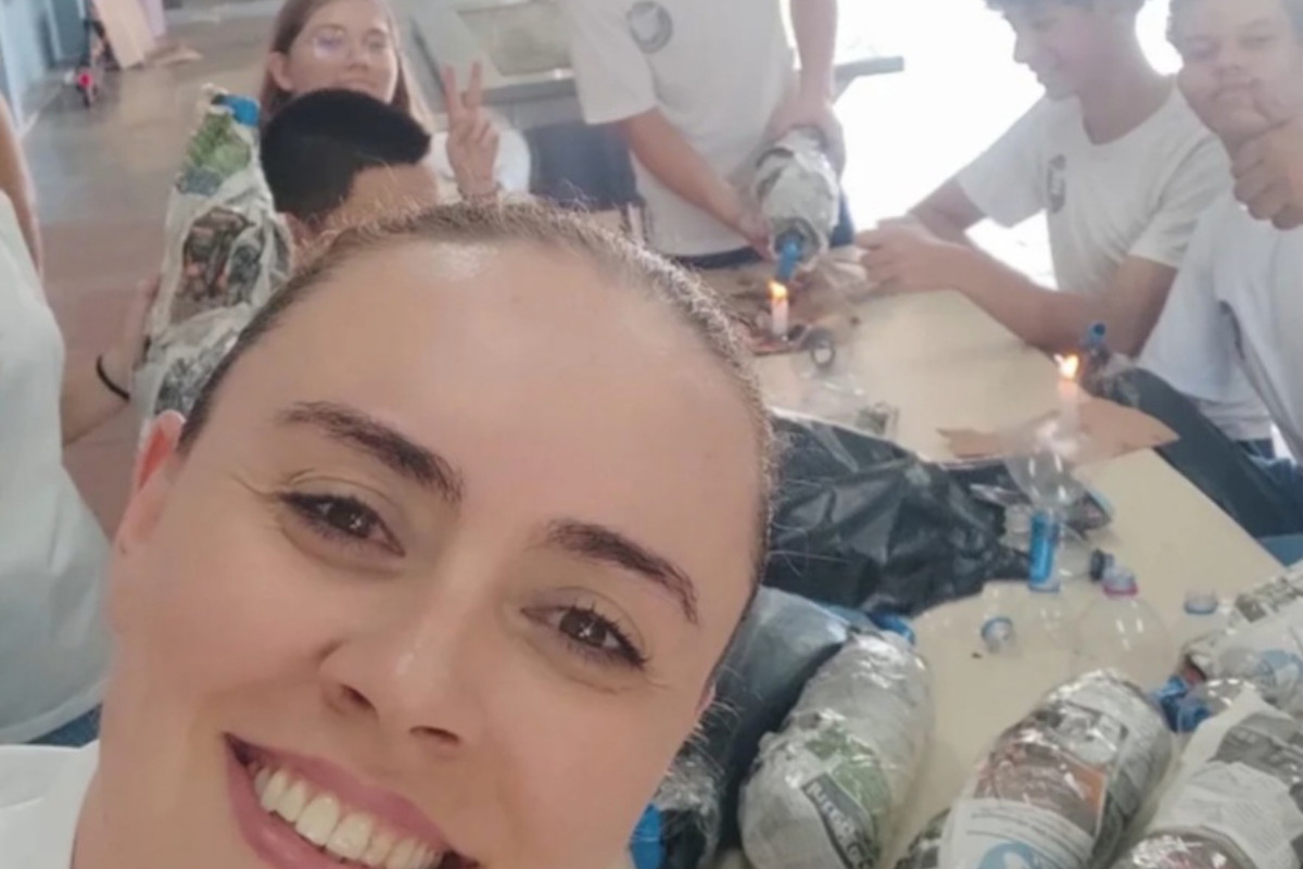 A imagem mostra um grupo de alunos e a professora coordenadora do clube montando armadilhas para capturar as abelhas Jataí. O equipamento é feito com garrafas PET.