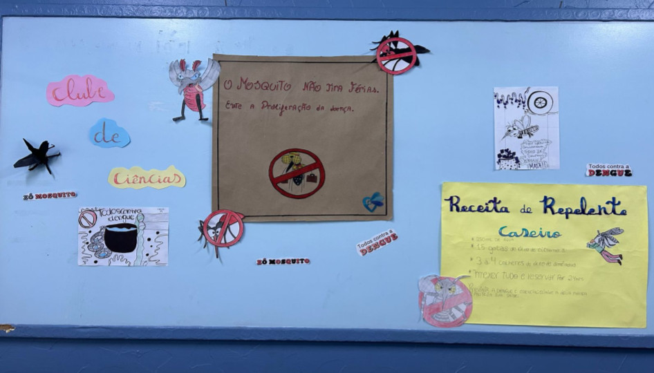 A galeria registra momentos da Culminância do Colégio Estadual Guilherme de Almeida, em Santa Izabel do Oeste (PR). Em um auditório com carteiras enfileiradas, palco, cortinas e projetor, professores e clubistas apresentam os projetos desenvolvidos ao longo do ano de 2025. Há, ainda, imagens de um panfleto intitulado 'Agrotóxicos e o Câncer de Mama' e outros momentos marcantes do clube.