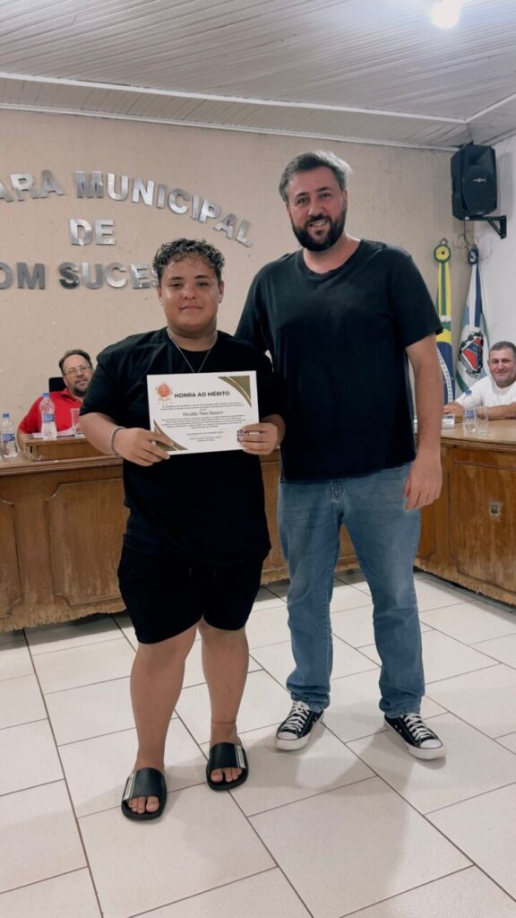 A galeria mostra momentos da entrega de certificados aos alunos do Colégio Estadual João Paulo I, da cidade de Bom Sucesso (PR). A homenagem aconteceu em uma sessão da Câmara Municipal, realizada em uma sala com cadeiras enfileiradas para o público em geral, caixas de som, microfones, bandeiras e mesas com identificações das autoridades presentes.
