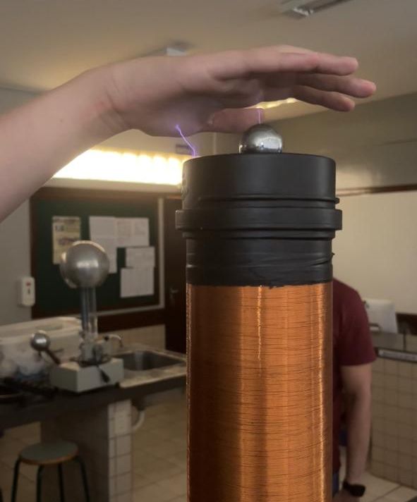 O aluno clubista com a mão sobre a bobina de Tesla faz o experimento na prática no laboratório, ao testar altas frequências e tensões, é utilizada nessa demonstração científica durante a atividade “Show da Física”do Clube Verde em Ação, do Colégio Estadual Pacaembu, conduzido pelo professor Oscar Rodrigues dos Santos. Experimentos de eletromagnetismo, centro de massa e vários outros para o nosso clube são importantes para todos os alunos que estão aprendendo na prática. É uma atividade que agrega muito ao clube e traz uma outra visão aos alunos participantes.