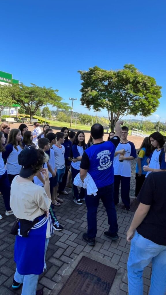A galeria registra os momentos da visita do clube ao campus da UFFS Realeza. As imagens externas destacam a área verde da universidade e os estudantes acompanhados pelo coordenador do projeto durante a visita guiada. Já os registros internos apresentam as atividades práticas realizadas no laboratório, onde os alunos participaram da oficina.