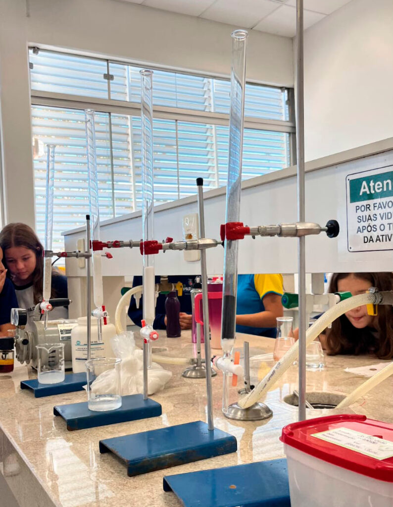 Momentos da Oficina Água realizada no laboratório da Universidade Federal da Fronteira Sul, campus Realeza. Nos detalhes, os alunos manuseando equipamentos como conta-gotas e as vidrarias de laboratório