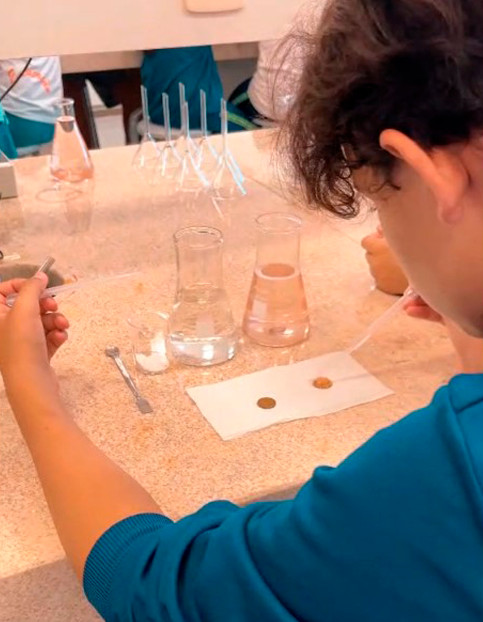 Momentos da Oficina Água realizada no laboratório da Universidade Federal da Fronteira Sul, campus Realeza. Nos detalhes, os alunos manuseando equipamentos como conta-gotas e as vidrarias de laboratório