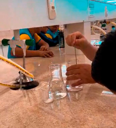 Momentos da Oficina Água realizada no laboratório da Universidade Federal da Fronteira Sul, campus Realeza. Nos detalhes, os alunos manuseando equipamentos como conta-gotas e as vidrarias de laboratório