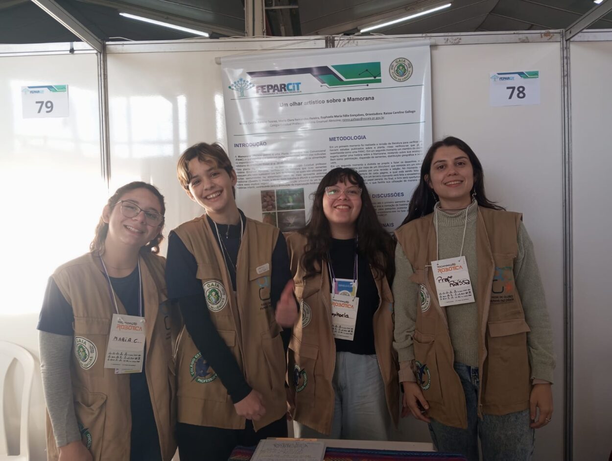 Clubistas e professora do Clube Gaia em foto em frente ao banner de sua apresentação na feira FEPARCIT.