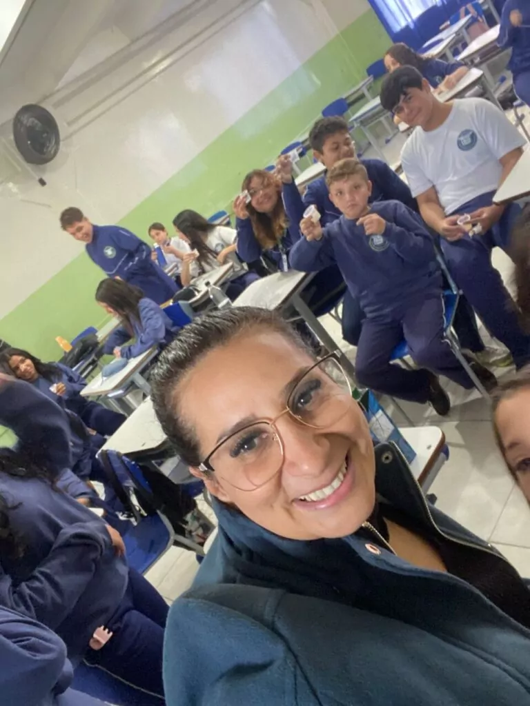 A galeria de fotos mostra momentos da apresentação e degustação do energético produzido pelo clube de ciências Ciência na Mesa. As imagens mostram estudantes na sala de aula com as mesas organizadas para oferecer o energético em copo descartáveis. Todos parecem felizes, sorrindo e curiosos com a proposta de bebida alternativa
