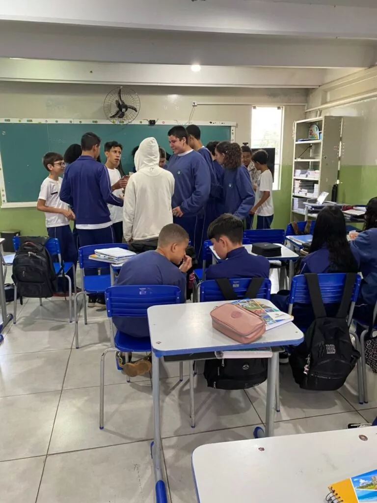 A galeria de fotos mostra momentos da apresentação e degustação do energético produzido pelo clube de ciências Ciência na Mesa. As imagens mostram estudantes na sala de aula com as mesas organizadas para oferecer o energético em copo descartáveis. Todos parecem felizes, sorrindo e curiosos com a proposta de bebida alternativa