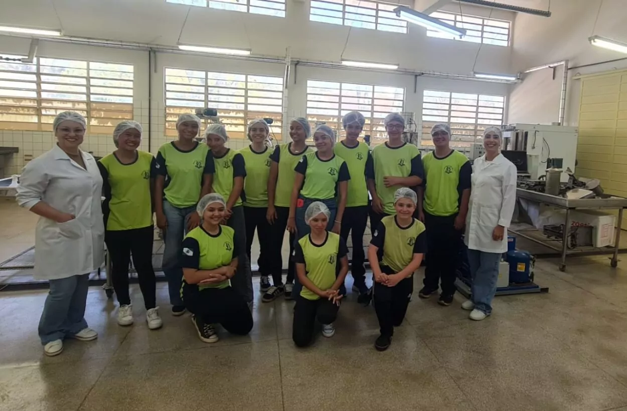 Na primeira fotografia é possível ver um grupo de pessoas posando juntas dentro de uma sala de aula. Ao todo, são dez pessoas: oito jovens e dois adultos. Eles estão posicionados lado a lado. O ambiente é típico de sala de aula, com paredes amarelas, quadro verde ao fundo e piso de cerâmica. A segunda imagem é do Clube Ilha da Ciência. A imagem mostra um grupo de estudantes e duas mulheres posando em um ambiente ao ar livre, com árvores, arbustos e canteiros de horta ao fundo. O grupo está sorridente, alguns em pé e outros agachados na frente. Na terceira fotografia tem um grupo de estudantes reunidos em um ambiente escolar ao ar livre, em frente a um jardim vertical com diversas plantas verdes. Eles estão distribuídos em pé e agachados, posando para a foto. A quarta imagem mostra um grupo de estudantes e um adulto reunidos em um espaço ao ar livre, posando para uma foto em frente a uma grande escultura de uma figura humana com os braços abertos. O grupo está distribuído sobre um pequeno morro coberto de grama, alguns sentados e outros em pé. A quinta imagem é do Clube Experimentando a Ciência: Descobrindo cores e novos sabores. A imagem mostra um grupo de estudantes e professores posando para uma foto ao ar livre, em frente a uma placa de madeira com o desenho de uma abelha e a palavra “Meliponário”. Estão sorridentes e organizados ao redor da placa. Na sexta imagem mostra um grupo grande de pessoas, formado por adolescentes e um adulto, posando para uma foto em uma sala. Eles estão organizados em duas fileiras: alguns sentados ou agachados na frente. A sala tem paredes claras, ventiladores fixados na parede e um quadro branco ao fundo. À esquerda, há uma mesa com uma toalha vermelha e alguns objetos decorativos para um evento escolar. A última fotografia tem um grupo de estudantes e alguns adultos reunidos para uma foto em um ambiente escolar externo. Eles estão em frente a uma parede branca com detalhes verdes e uma janela comprida com grades. O grupo está posicionado em duas fileiras, com alguns agachados na frente e outros em pé atrás, todos sorrindo.